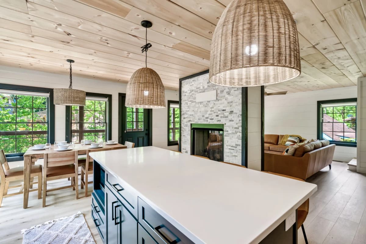Whispering Pines living and dining area with a stone fireplace, set for a group