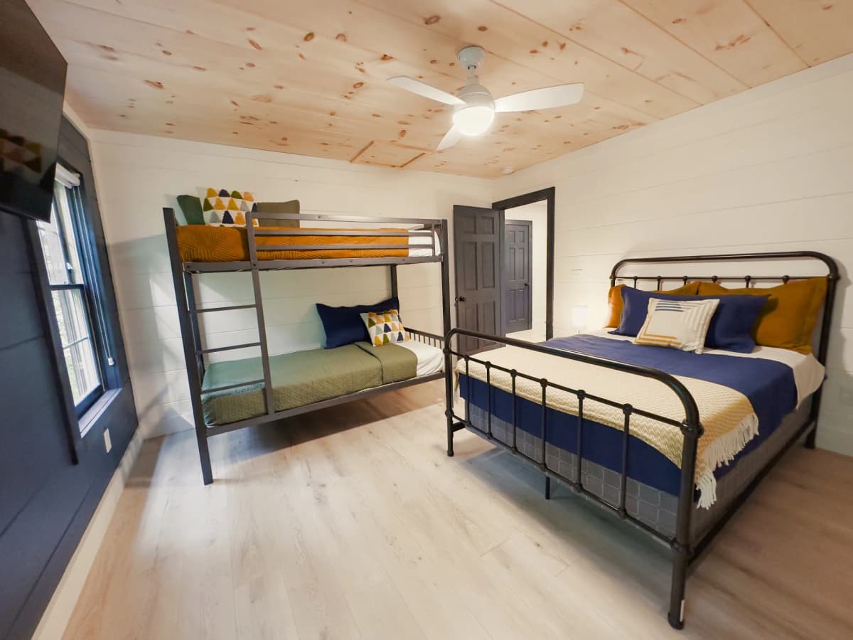 Family bedroom with bunk beds at Whispering Pines Lodge — one of four bedrooms in the cabin that sleeps 12